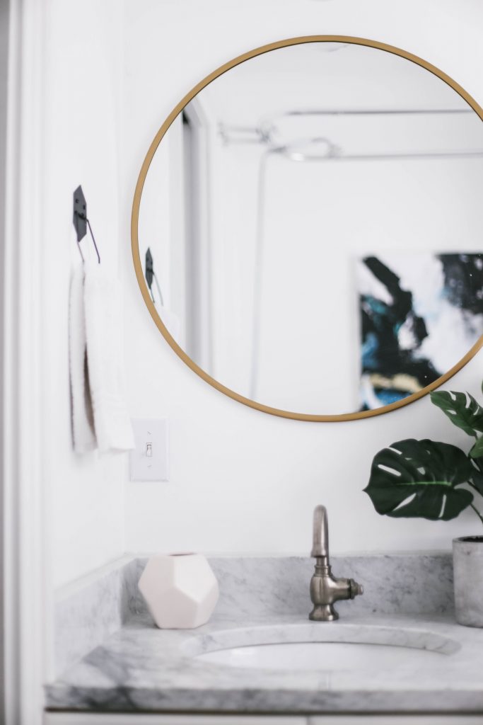 Guest Bathroom Reveal Modern Historic Downtown Charleston Home Renovation   // Charleston Fashion Blogger Dannon Like The Yogurt    Urban Outfitters black hexagon hand towel ring DIY cedar and moss brass sconce white clawfoot tub shower round brass vanity mirror target cement planter hex white vase white walls marble cararra countertops black and white geometric kilum rug nate burkus